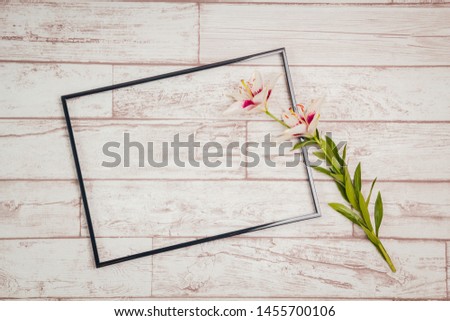 Photo frame and flower on wood