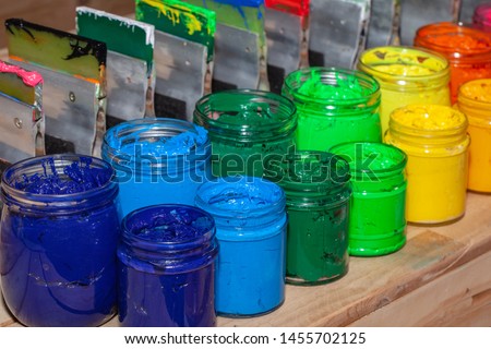 colorful plastisol ink in transparent bottles in screen printing tee shirt factory store.