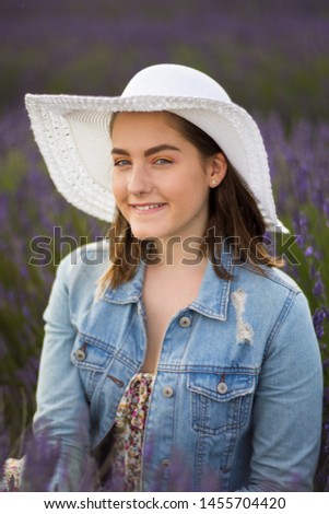 English Female teen model wearing a straw hat in a Lavender field during summertime
in England.