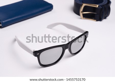 Mirror sunglasses on white background closeup. Leather wallet and belt behind a sunglasses. Stock photo of fashion accessories.