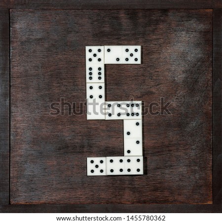 alphabet of dominoes on wooden background, letter S
