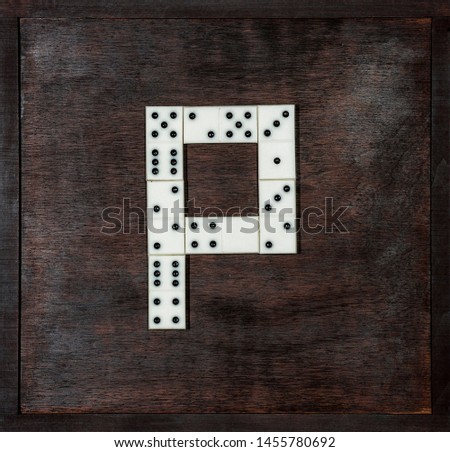 alphabet of dominoes on wooden background, letter P