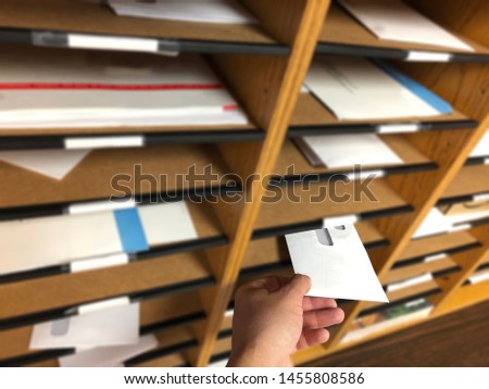 Man´s Hand Delivering & Receiving Mail from a Mailbox Sorter inside the Office. Royalty-Free Stock Photo #1455808586