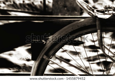 Detail of the wheel of a bicycle parked on the waterfront