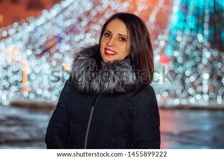 Night art portrait of attractive young woman on city lights background. Gorgeous brunette girl, portrait in night city lights. Emotional photo. Christmas wondering night, street garland