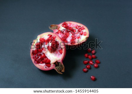 Ripe pomegranate fruit on dark background.
