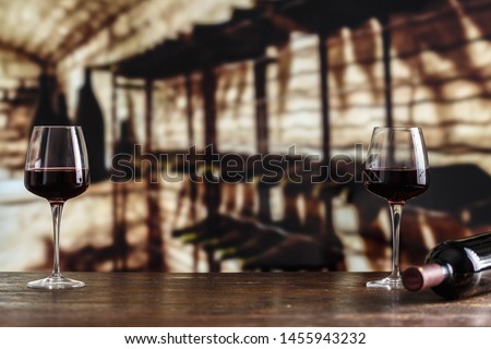 red wine in a glass on the background of a cellar, vintage picture for a wine card
