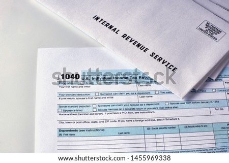 Three mails from the Internal Revenue Service lie on 1040, Schedule D form 1040 and 1040a tax forms Royalty-Free Stock Photo #1455969338
