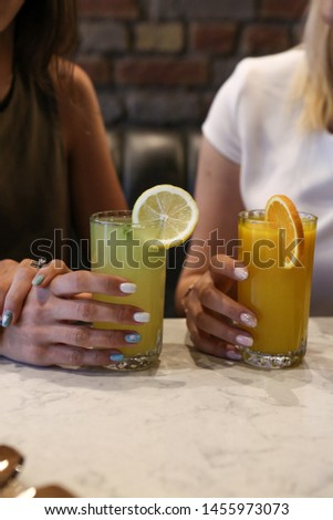 delicious colored cocktail in the hand at girls