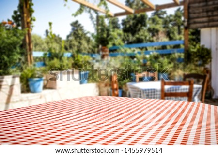 Table background with empty space for an advertising product and garden view in distance.