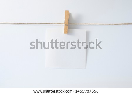 A little sheet of paper hold by a clipboard on a string.