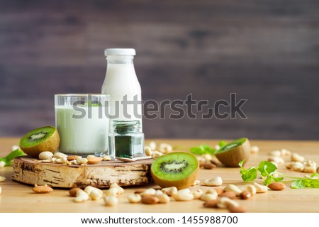 Organic summer breakfast with superfood spirulina, yogurt, kiwi, mint and nuts on wooden table. Meal that promotes good digestion and functioning of gastrointestinal tract. Healthy food concept. Royalty-Free Stock Photo #1455988700