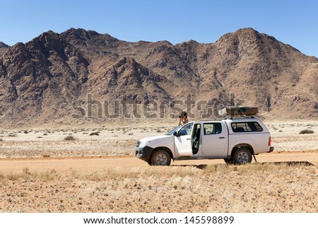 photographer on safari in Africa on his car