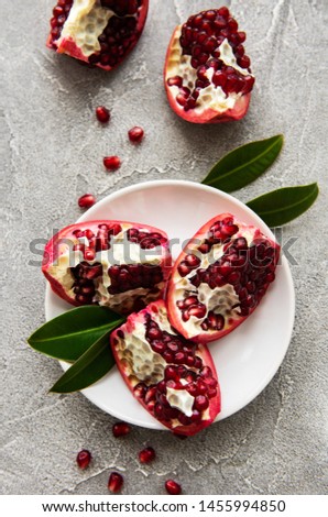 Ripe pomegranate fruits on  grey concrete background