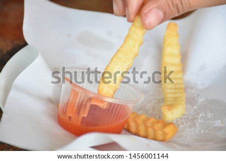 Crispy fried potato sticks eaten with tomato sauce