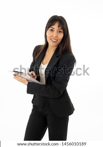 Close up of a young beautiful business woman standing holding a folder. Smiling feeling confident and successful. In people business education, success and work environment concept.