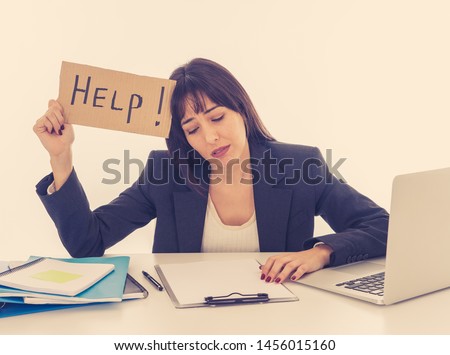 Young beautiful business woman suffering stress working at desk holding help sign feeling tired and frustrated looking overworked and overwhelmed. In business education, fail and technology concept.