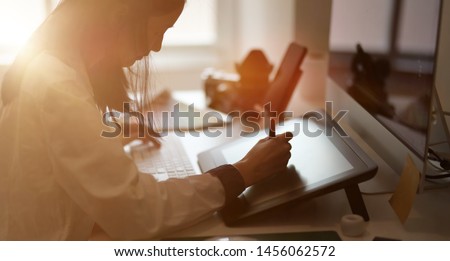 Young female graphic designer sketching on her project with modern creative work place   Royalty-Free Stock Photo #1456062572