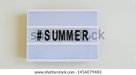 Summer Time White Lightbox Banner Sign with Black Letters and Decorative Clothes Hanger on Glossy Table and White Background