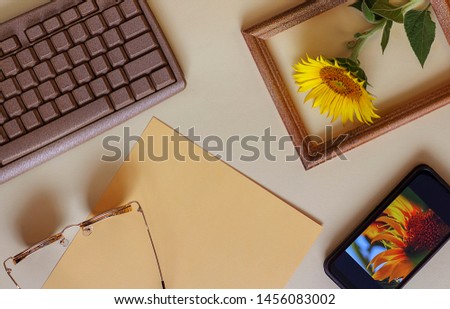 Office or school layouts on a light background. Keyboard, glasses, paper, sunflower and phone. On the screen of the phone is my picture IMG _5434. Back to school, concept. Top view, flat lay.