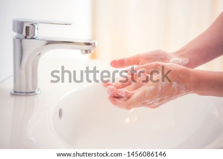 Washing hands with soap under the faucet with water. Hygiene concept. Royalty-Free Stock Photo #1456086146