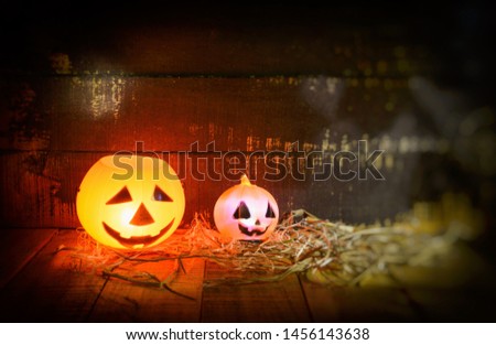 Halloween pumpkin lantern with dry straw on wooden / head jack o lantern evil faces spooky holiday decorate on halloween background 