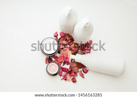 Skincare cosmetics with a moisturizer placed in a cream tube. Side decorated with dried flowers. White background.