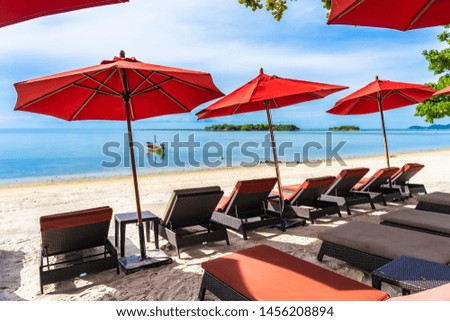 Beautiful outdoor tropical beach sea ocean with umbrella chair and lounge deck on white cloud blue sky background for holiday vacation travel