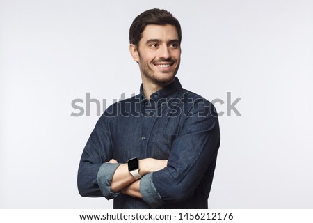 Ambitious guy looking sideways with arms crossed as if planning strategy of business development, isolated on grey background Royalty-Free Stock Photo #1456212176