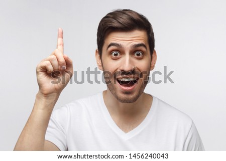 I have an idea! Handsome man keeping finger pointed upwards, showing something above  head, making gesture with index finger. Eureka, solution sign concept