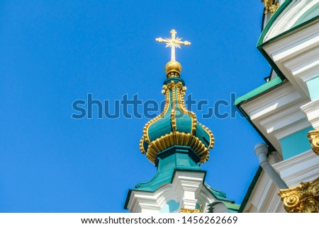 Close up on the tower of St Andrew's Church, Kiev, Ukraine. The church is small and painted blue and white with many decorations on it's facade. Picture taken from under the church. Clear and blue sky