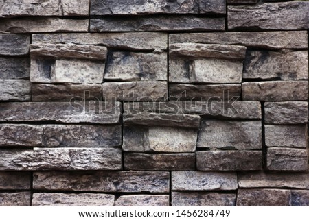 The wall texture of crushed natural stone of rectangular shape, gray. Photo for wallpaper, concept of construction and natural natural building materials.
