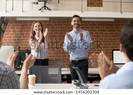 Excited company managers stand applauding congratulating team with work success, boss or CEO clap greeting coworker with promotion or goal achievement, supporting colleague. Reward concept Royalty-Free Stock Photo #1456302308