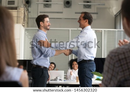 Boss or CEO shake hand of male employee congratulating with job promotion at work, company employer handshake newcomer or newbie greeting with employment or hiring. Recruitment concept