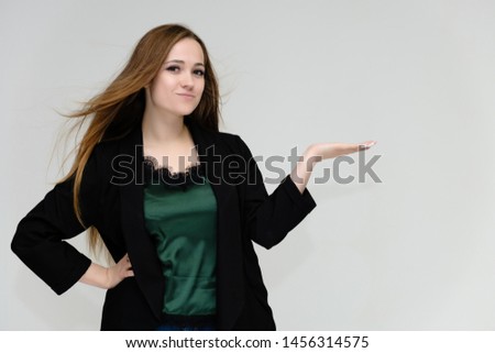 Concept portrait for the waist of a pretty girl, a young woman with long beautiful brown hair and a black jacket and blue jeans on a white background. In studio in different poses showing emotions.