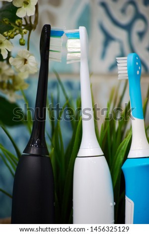 electric sonic toothbrushes for family in the bathroom with green decorative plants