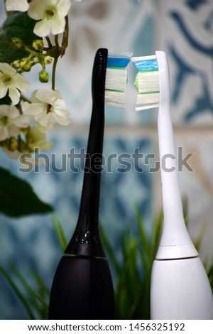 electric sonic toothbrushes for lovers in the bathroom with green decorative plants