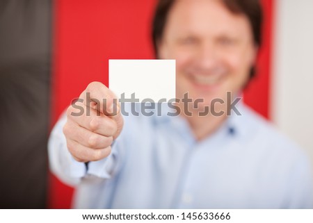 friendly smiling man in a shop showing white card