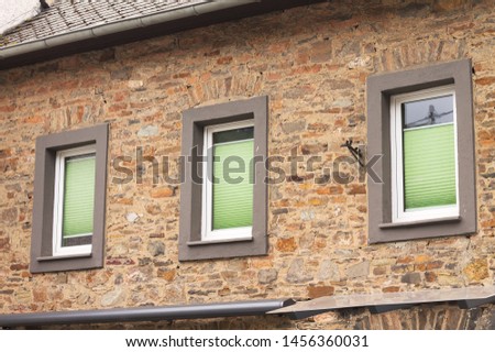 Three windows with green shutters in a brick wall (Germany, Europe)