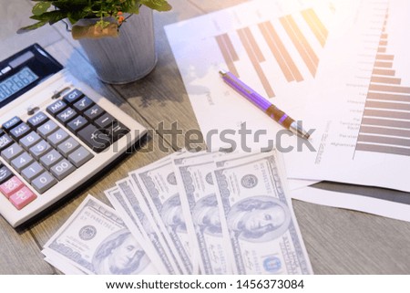 Dollars and calculators and flowers on the desk