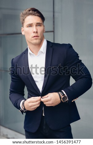businessman in the city. portrait of young man. glass building. photo shoot on the street