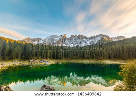Lake Carezza or Karersee at sunset, wide angle view of scenic landscape in Italy. Dolomites mountains on background, Italian Alps. Nature and travel concepts, long exposure photo