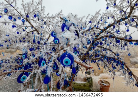 Blue evil eye / nazar boncuğu, Turkish symbols hanging on a tree; Cappadocia