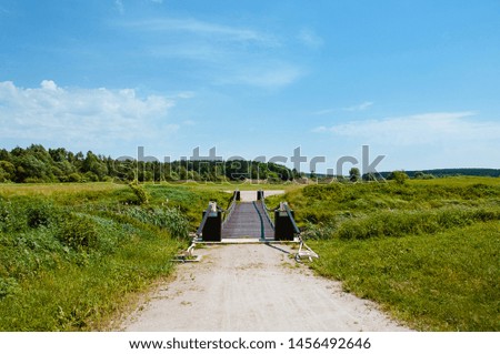 Bridge with wooden railings on the golf course. Beautiful nature and cloudy sky.