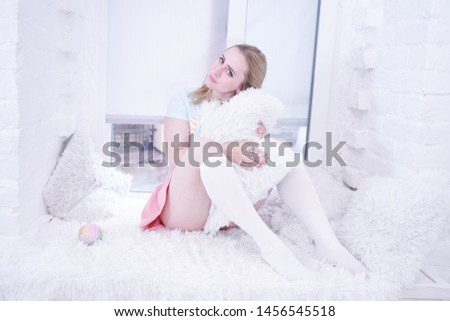 cute girl relax on white windowsill with fur pillows alone