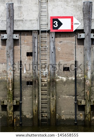 jetty with a ladder and a sign at the harbor of Hamburg (Germany)