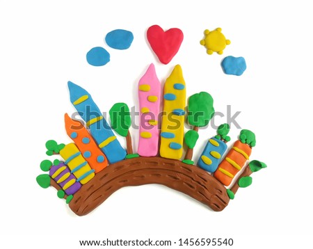 The city with fresh air is made from colorful clay plasticine on white background, many tall buildings and trees beneath the bright sky are beautiful town dough
