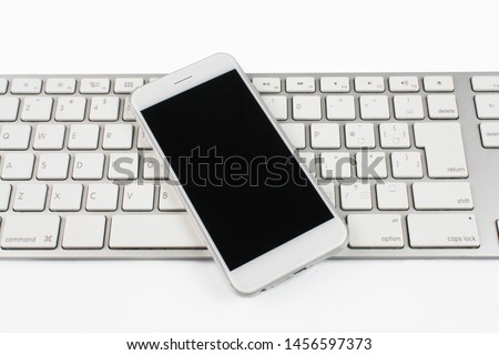 Smartphone and computer keyboard on white background