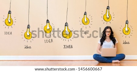 Idea light bulbs with young woman using a laptop computer