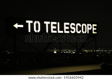 lit up to telescope sign at night
